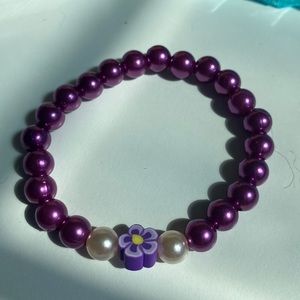 Purple flower charm in the middle with white hair mean